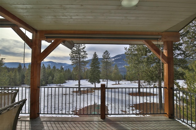 snow covered deck featuring a mountain view