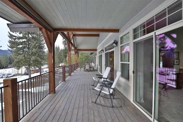 snow covered deck featuring a porch and a mountain view