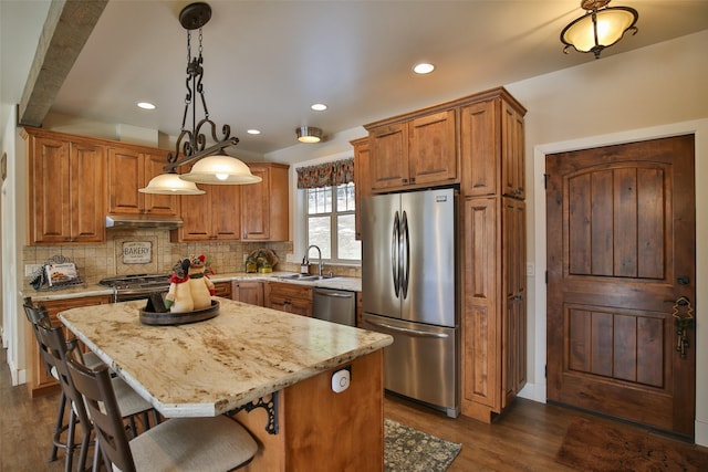 kitchen with sink, dark hardwood / wood-style flooring, hanging light fixtures, a center island, and stainless steel appliances