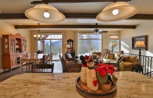 dining space with dark hardwood / wood-style flooring, a mountain view, and ceiling fan with notable chandelier