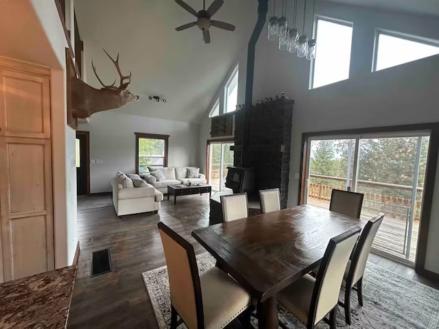 dining space with dark hardwood / wood-style flooring, a healthy amount of sunlight, ceiling fan, and high vaulted ceiling