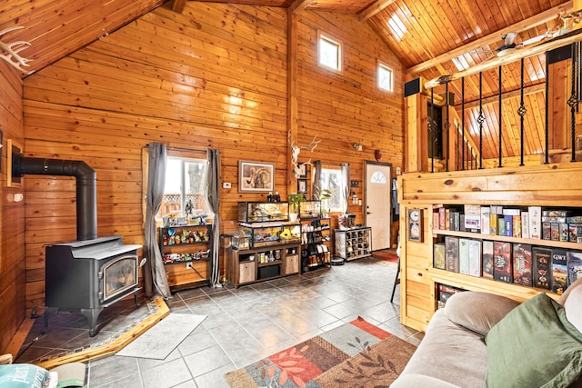 tiled living room featuring high vaulted ceiling, a wood stove, wood ceiling, and wooden walls