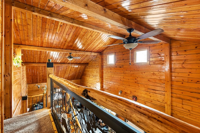 corridor with lofted ceiling with beams, wood ceiling, and wooden walls