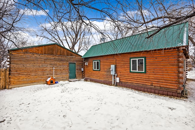 view of snow covered rear of property