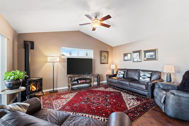 living room with lofted ceiling, dark hardwood / wood-style floors, ceiling fan, and a wood stove