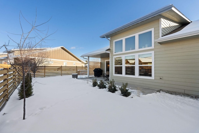 view of snow covered back of property