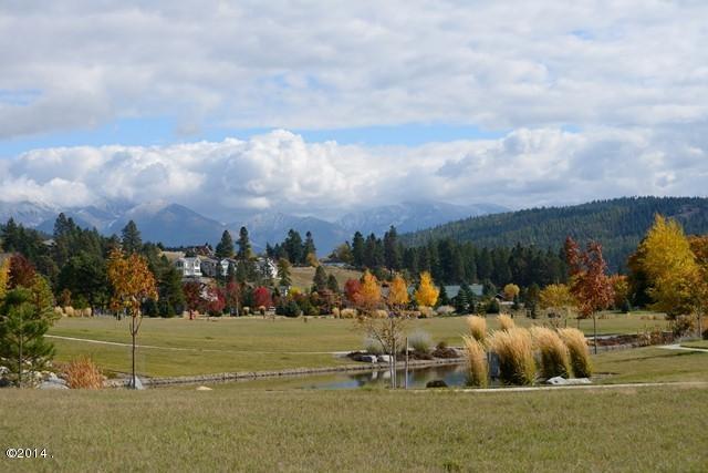 surrounding community with a rural view, a water and mountain view, and a lawn