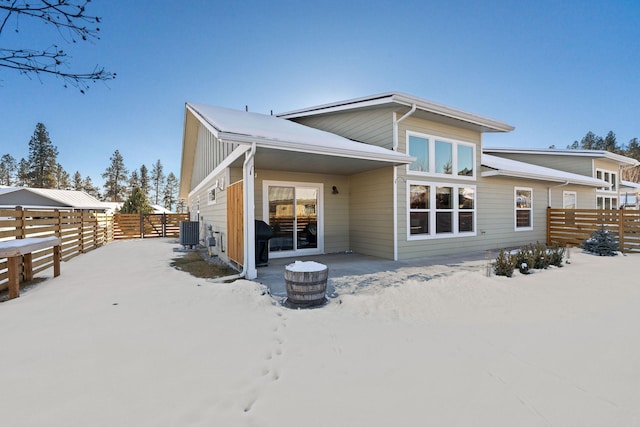 snow covered house featuring central AC