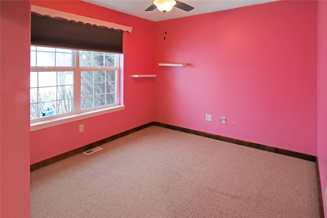 carpeted spare room featuring ceiling fan