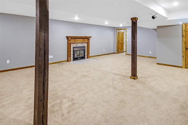 basement with a fireplace and light colored carpet