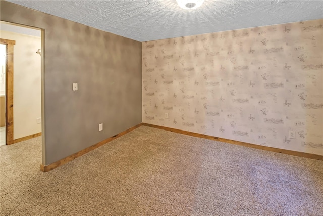 carpeted empty room with a textured ceiling