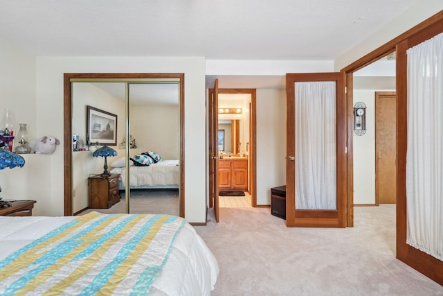 bedroom with light colored carpet, ensuite bathroom, and a closet