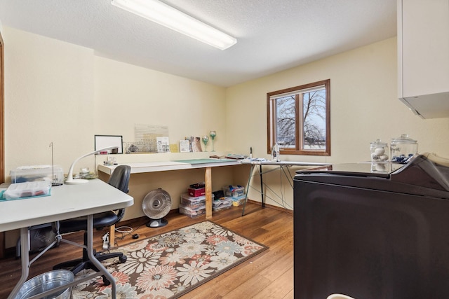 home office with washer / dryer, hardwood / wood-style floors, and a textured ceiling