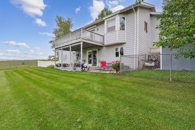 rear view of house featuring a patio, a yard, and a deck