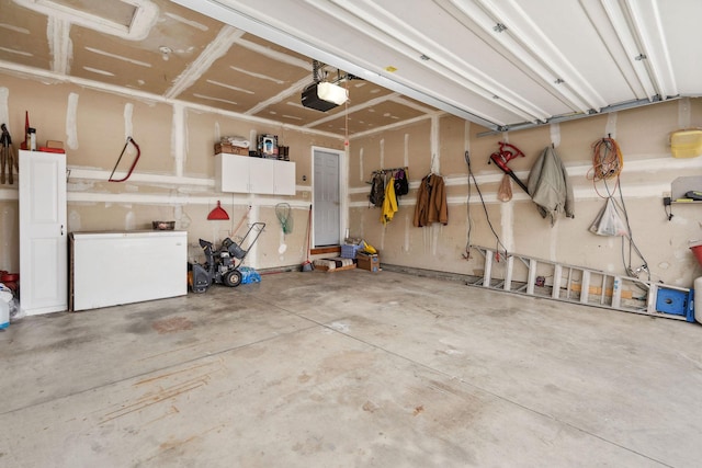 garage with a garage door opener and fridge