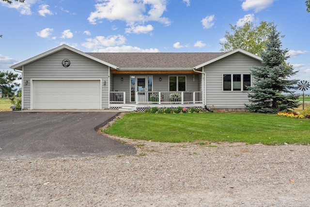 ranch-style house featuring a garage, covered porch, and a front lawn