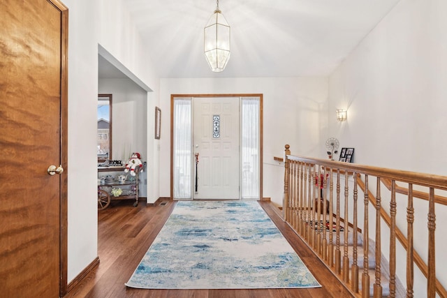 entryway with dark hardwood / wood-style floors and a notable chandelier