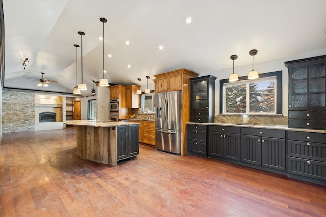 kitchen with stainless steel appliances, decorative light fixtures, and backsplash