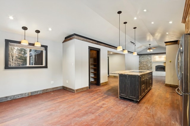 kitchen featuring pendant lighting, hardwood / wood-style flooring, stainless steel refrigerator, and a kitchen island