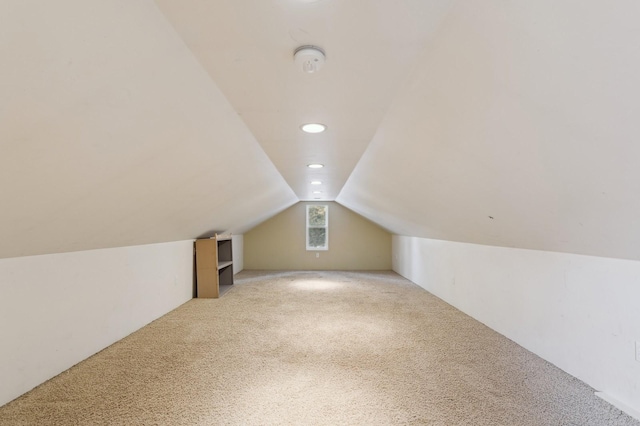 bonus room featuring vaulted ceiling and light carpet