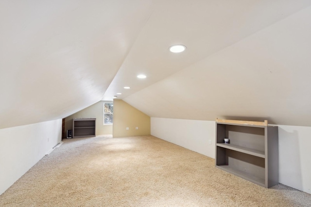 additional living space with vaulted ceiling and light carpet