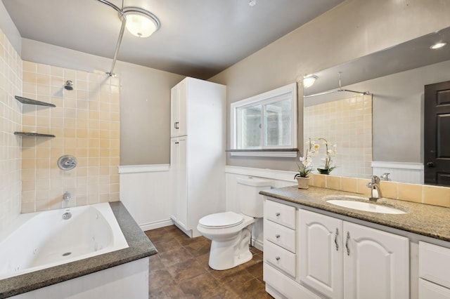 full bathroom featuring vanity, tiled shower / bath combo, and toilet