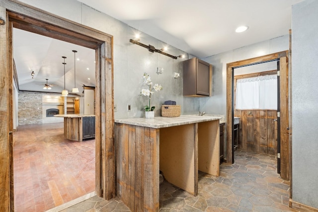 kitchen featuring vaulted ceiling, ceiling fan, and kitchen peninsula