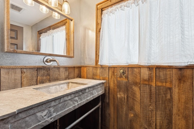 bathroom with vanity and wooden walls