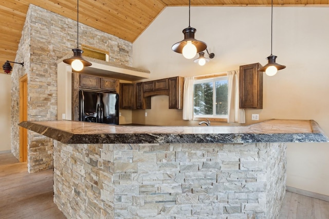 kitchen with pendant lighting, wood ceiling, high vaulted ceiling, black refrigerator with ice dispenser, and kitchen peninsula