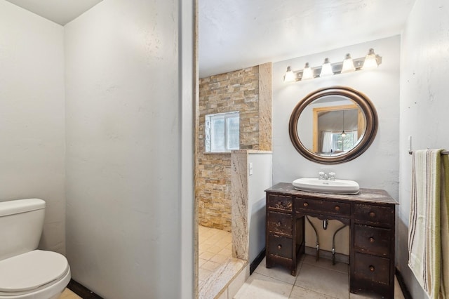 bathroom featuring toilet, vanity, and walk in shower