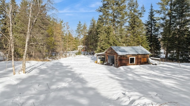 yard covered in snow featuring an outbuilding