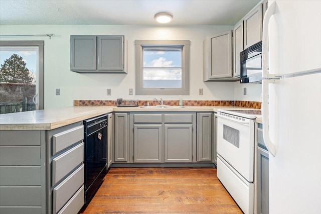 kitchen featuring gray cabinets, sink, kitchen peninsula, and black appliances