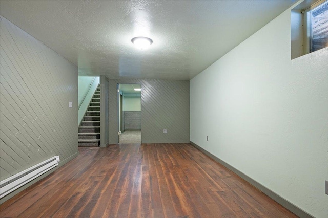 interior space with baseboard heating, dark wood-type flooring, and a textured ceiling