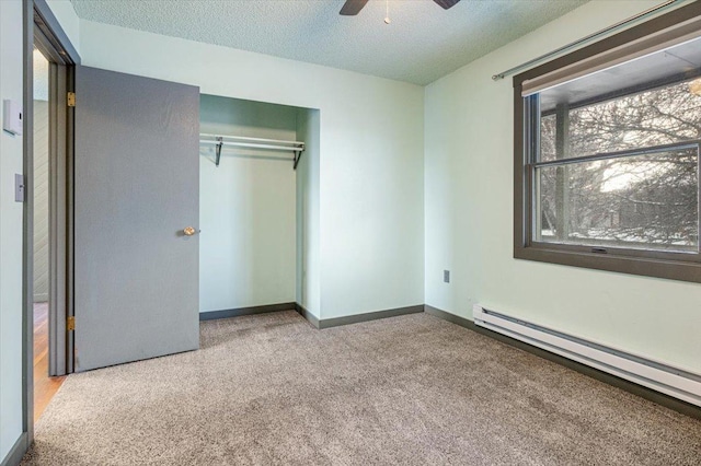 unfurnished bedroom with ceiling fan, baseboard heating, light carpet, a textured ceiling, and a closet