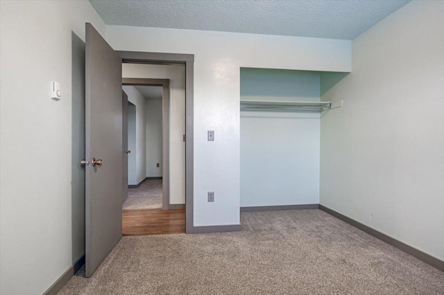 unfurnished bedroom with a closet, carpet flooring, and a textured ceiling