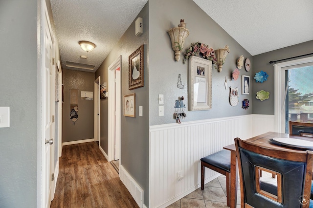 hallway with hardwood / wood-style flooring and a textured ceiling