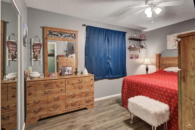 bedroom featuring hardwood / wood-style flooring, ceiling fan, and a textured ceiling