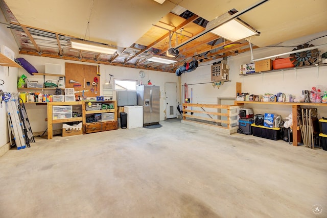 garage with a workshop area and stainless steel refrigerator with ice dispenser