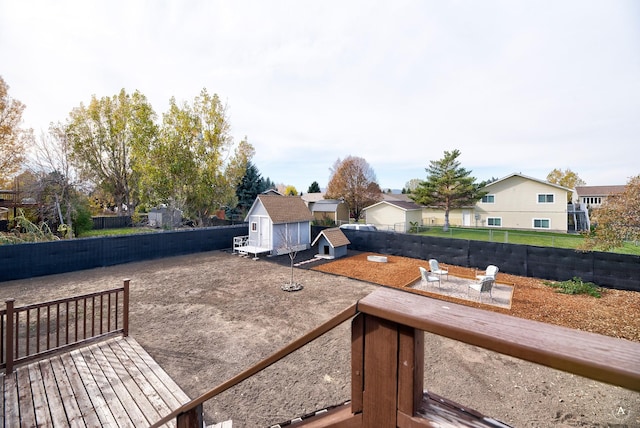 view of yard featuring a wooden deck and a storage shed