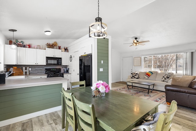 dining space with a ceiling fan and light wood-type flooring