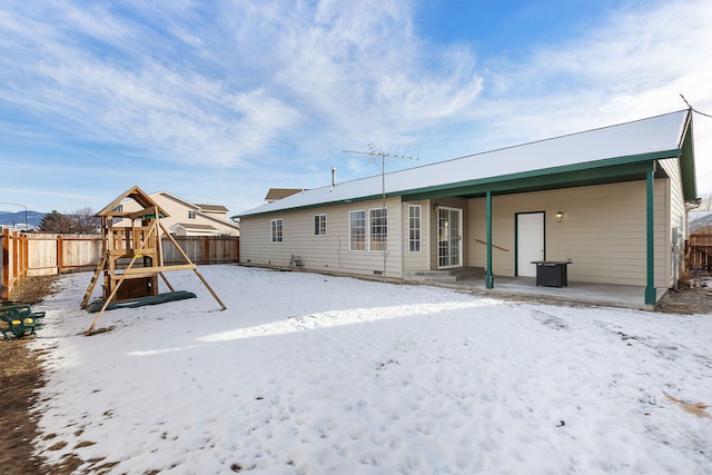 snow covered property with fence and a playground