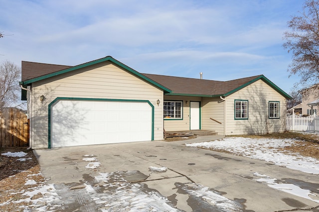 ranch-style house featuring fence, an attached garage, and concrete driveway