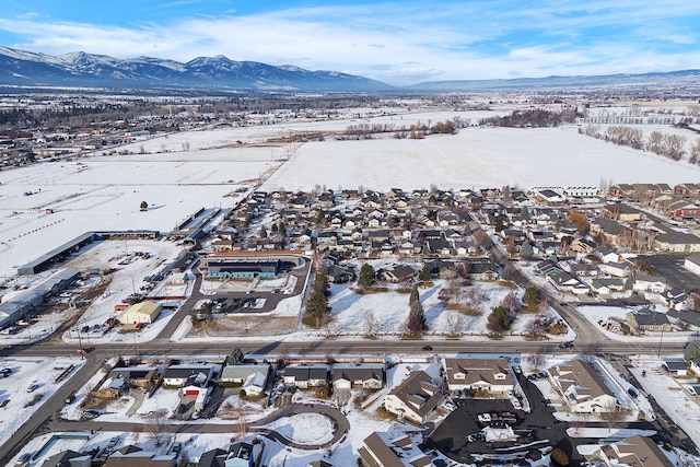 snowy aerial view featuring a residential view and a mountain view