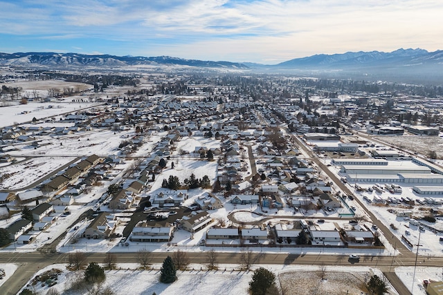 snowy aerial view featuring a residential view and a mountain view