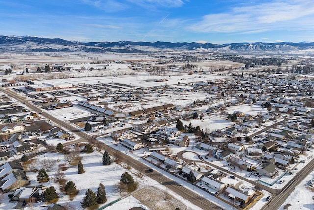 snowy aerial view with a residential view and a mountain view