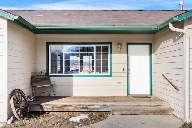 doorway to property with roof with shingles