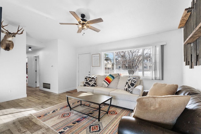 living area featuring ceiling fan, visible vents, baseboards, and wood finished floors