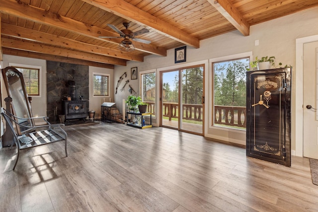 living area featuring a wood stove, hardwood / wood-style flooring, ceiling fan, wood ceiling, and beam ceiling