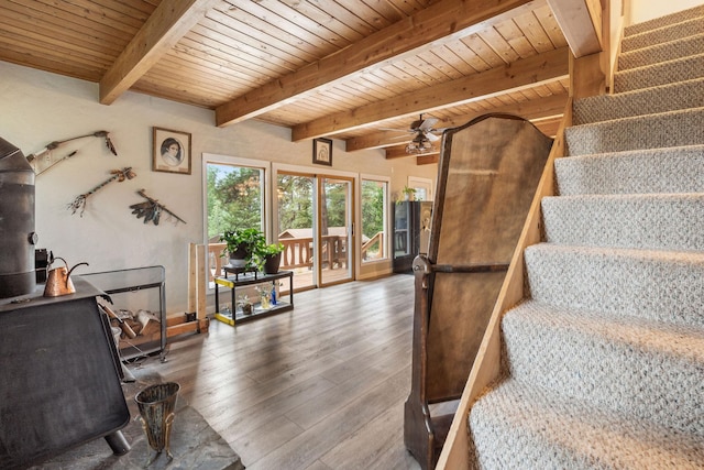 staircase featuring hardwood / wood-style flooring, wood ceiling, and beamed ceiling