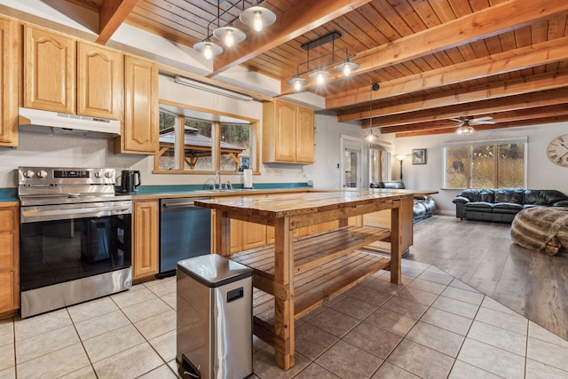 kitchen with light tile patterned floors, decorative light fixtures, stainless steel appliances, and a healthy amount of sunlight